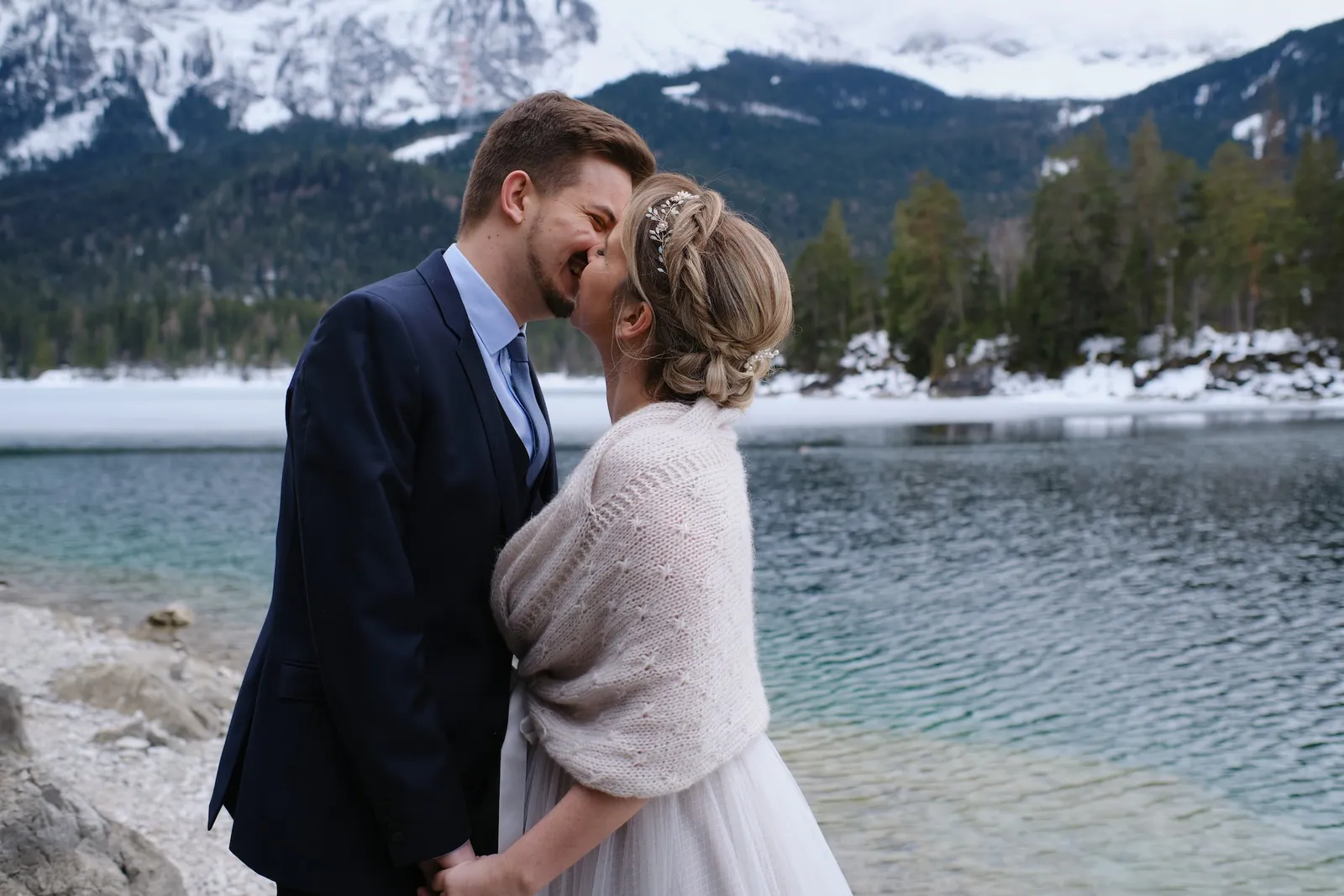 Enge Umarmung Stirn an Stirn am Eibsee, verschneite Berge und türkisgrünes Wasser im Hintergrund – After Wedding Christina & Florian, Eibsee