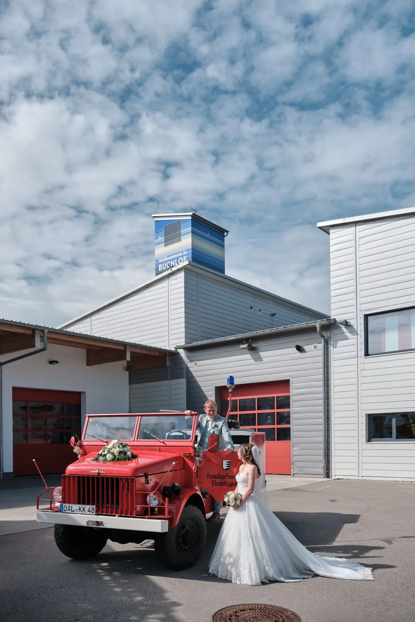 Brautpaar vor einem historischen Feuerwehrfahrzeug – Hochzeit Ronja & Markus, Feuerwehrhaus Buchloe
