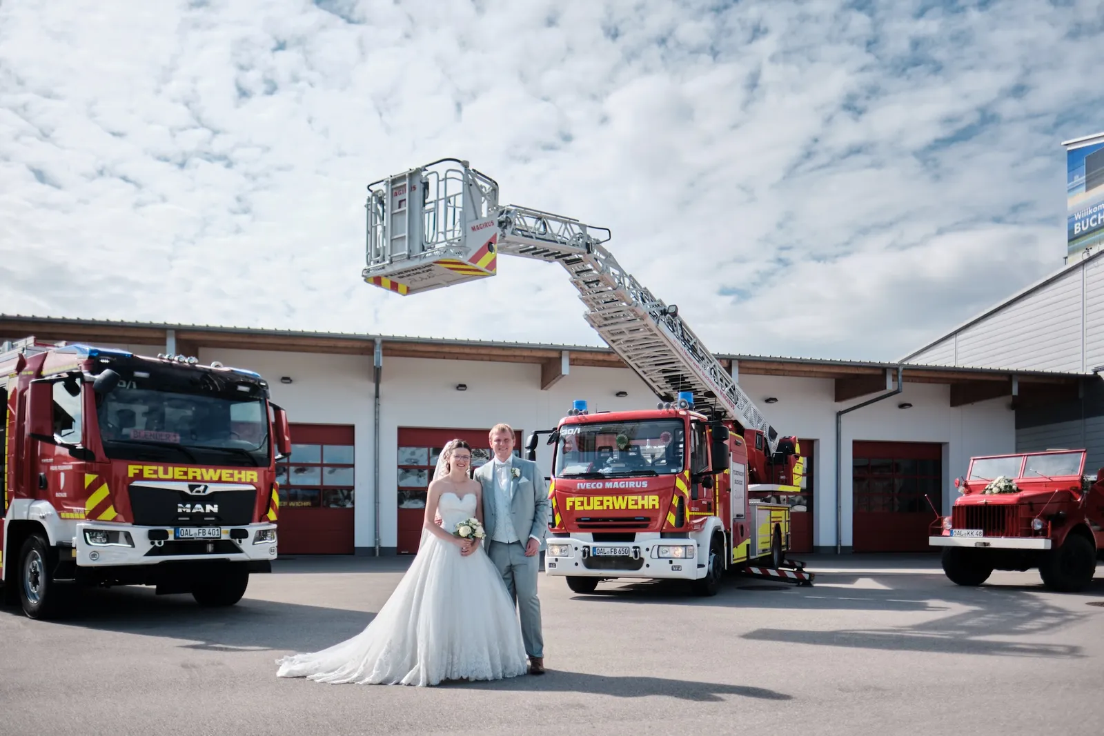 Die Drehleiter spannt sich über dem Brautpaar – Hochzeit Ronja & Markus, Feuerwehrhaus Buchloe