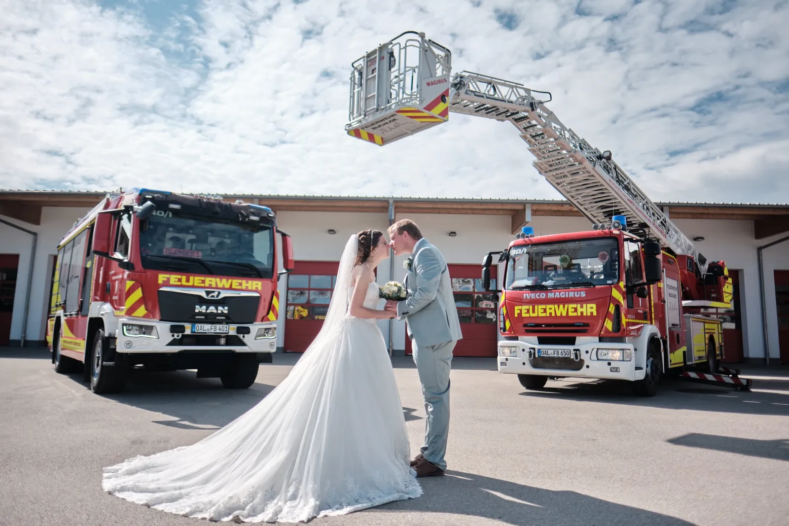 Brautpaar geht Hand in Hand über den Hof des Feuerwehrhauses – Hochzeit Ronja & Markus, Feuerwehrhaus Buchloe
