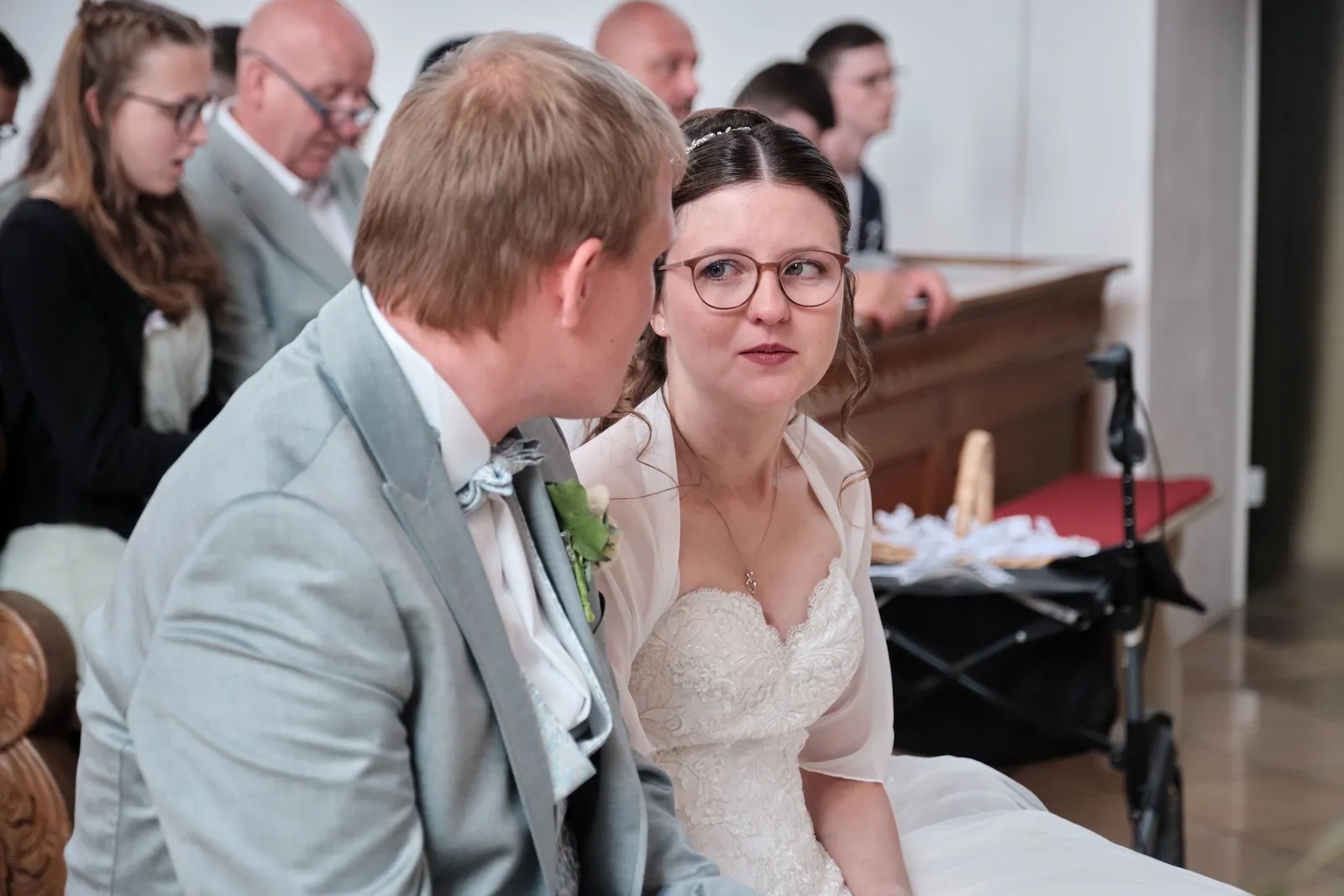 Brautpaar sitzt Seite an Seite in der Kirchenbank – Hochzeit Ronja & Markus, Buchloe