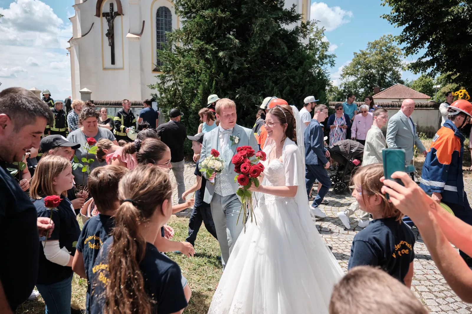 Kinder aus dem Ort gratulieren dem Brautpaar mit roten Rosen – Hochzeit Ronja & Markus, Buchloe