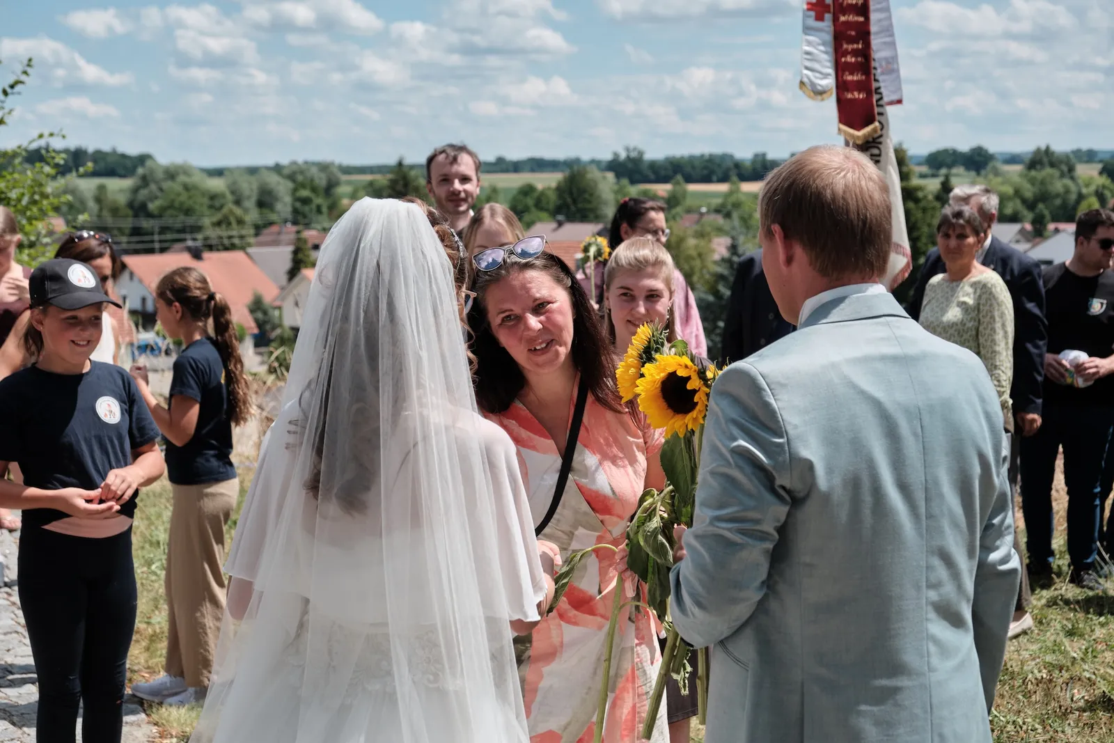 Ronjas Schleier weht im Wind vor der Kirche – Hochzeit Ronja & Markus, Buchloe