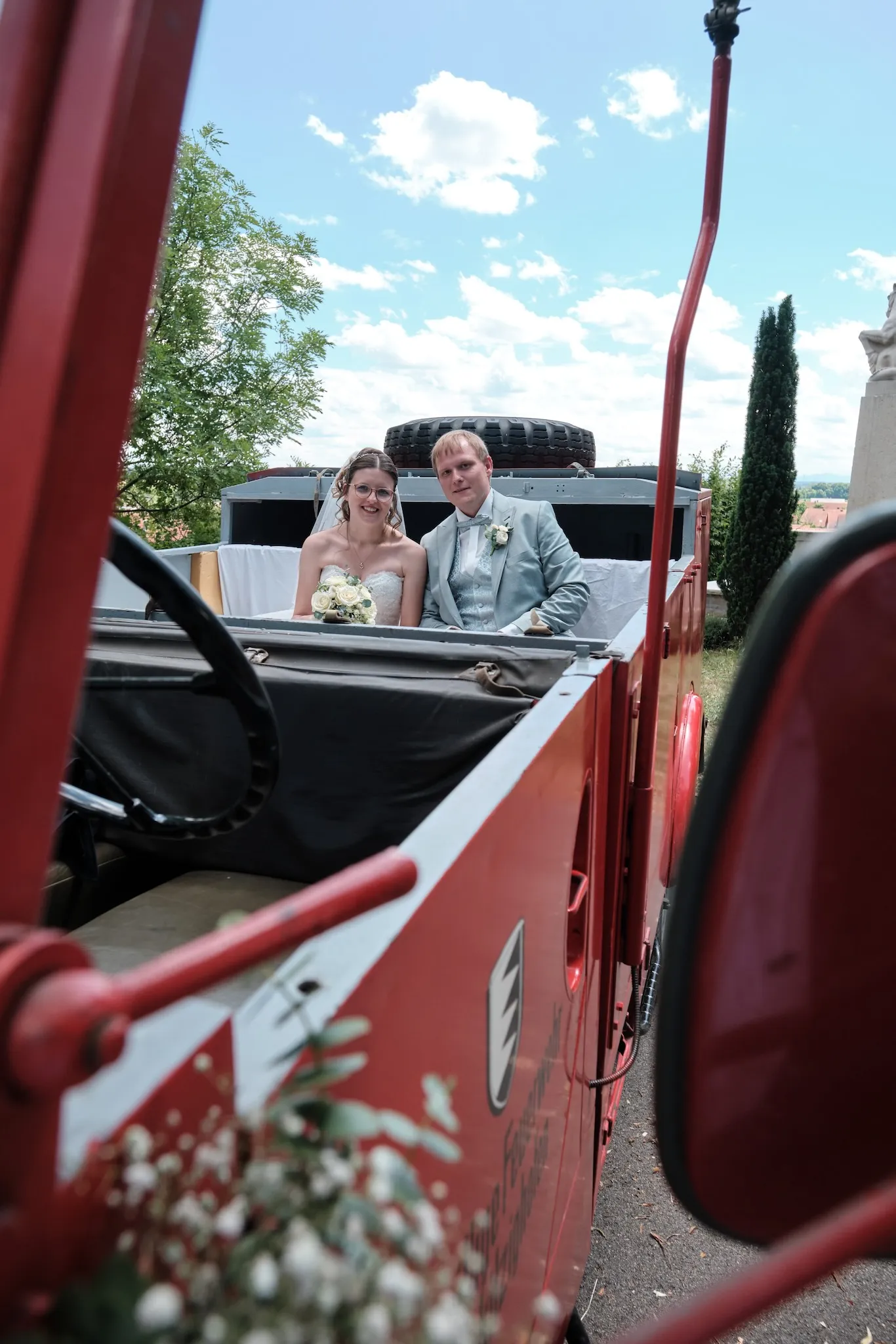 Brautpaar sitzt im offenen Oldtimer-Feuerwehrauto – Hochzeit Ronja & Markus, Buchloe
