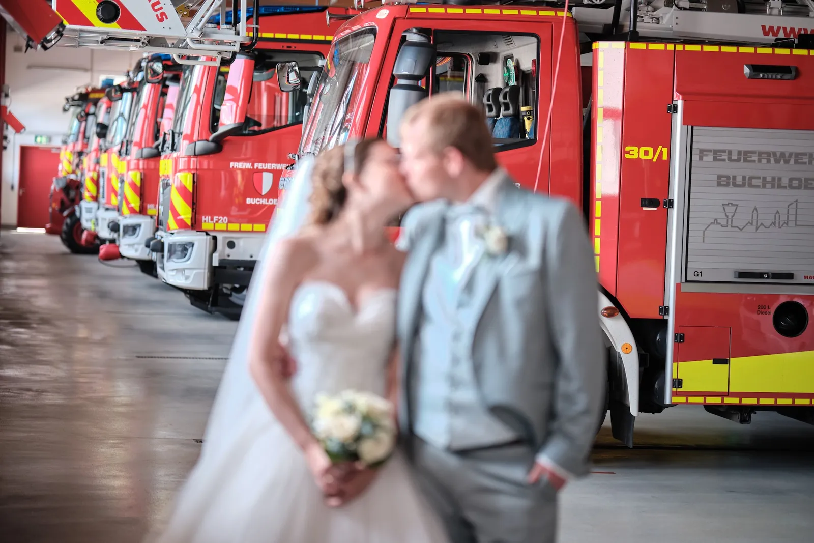 Kuss vor dem Feuerwehrauto am Abend – Hochzeit Ronja & Markus, Feuerwehrhaus Buchloe
