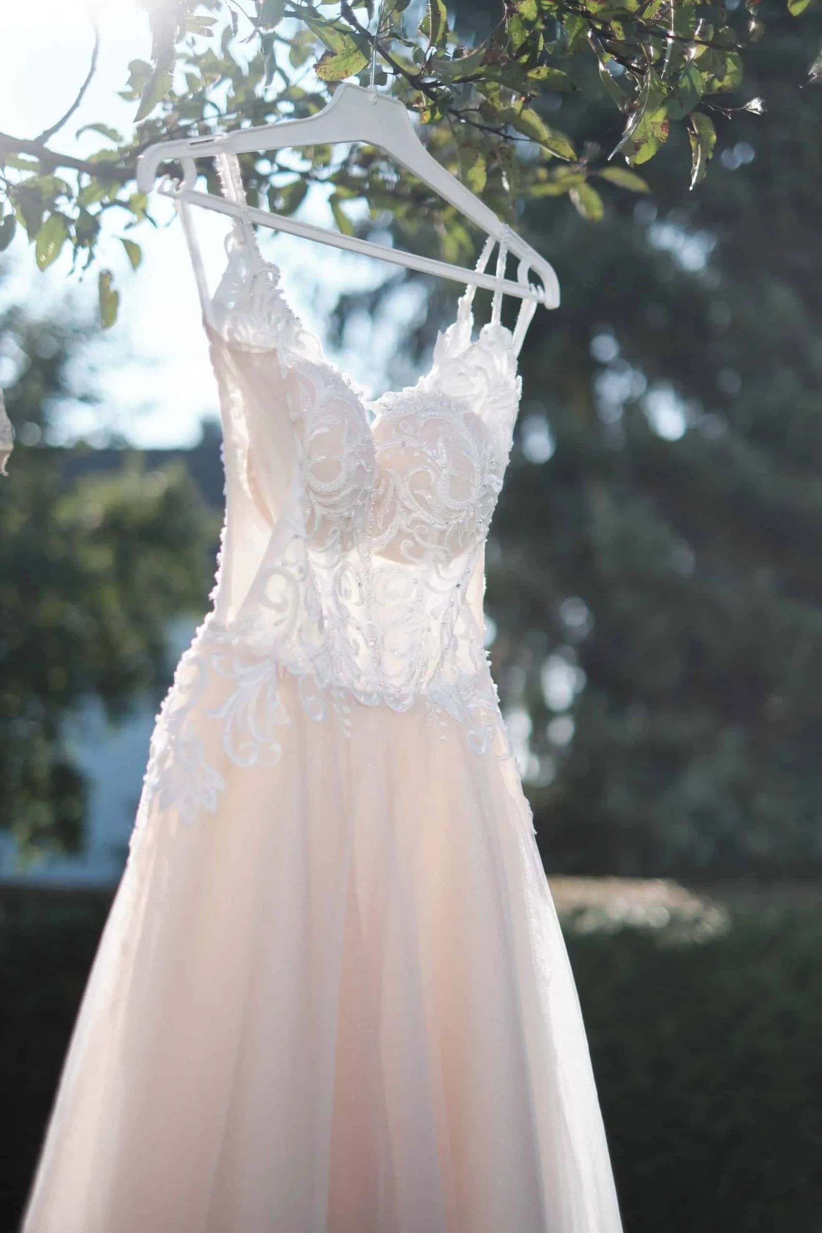 Brautkleid hängt auf einem Bügel an einem Baum – Hochzeit Charly & Moritz, Herrenhaus Bannacker