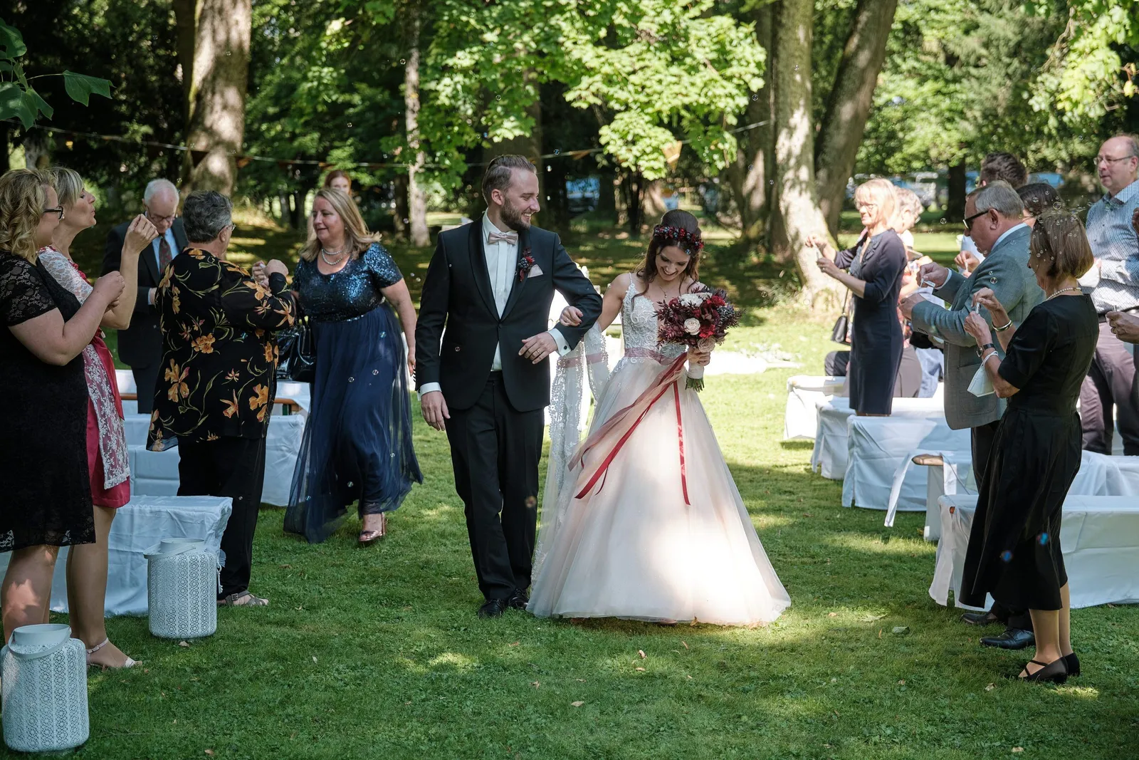 Brautpaar zieht nach der Trauung durch die applaudierenden Gäste aus – Hochzeit Charly & Moritz, Herrenhaus Bannacker