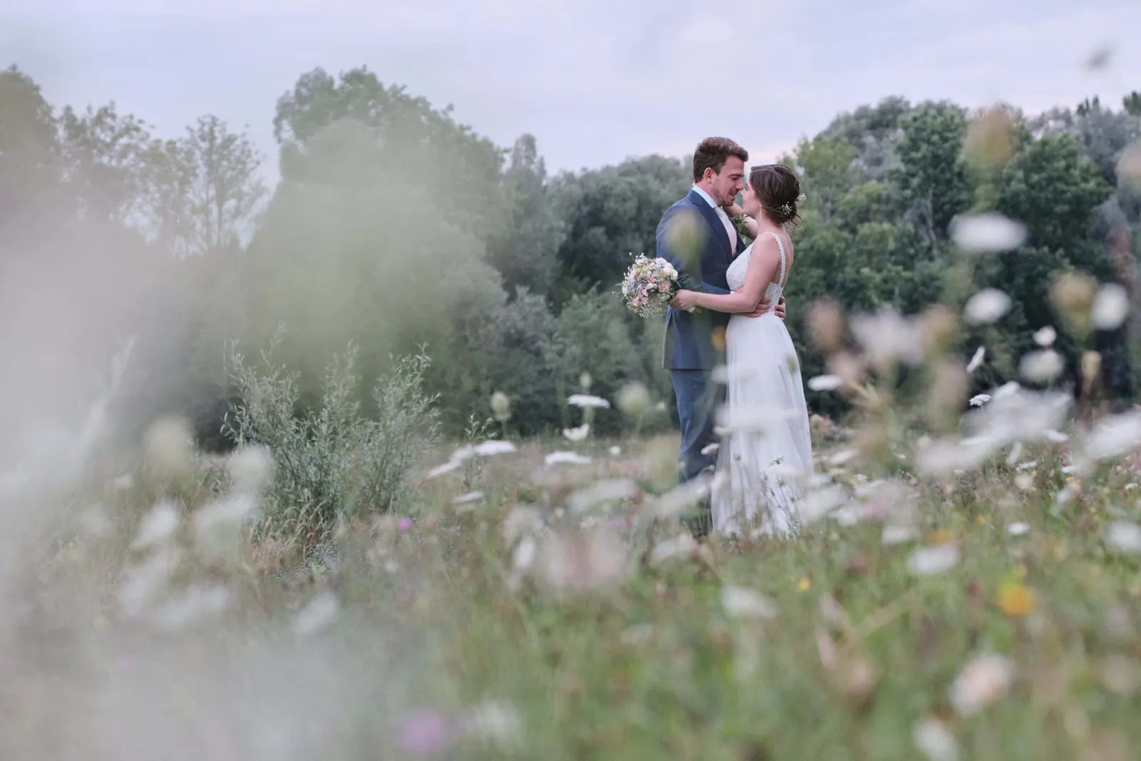 Brautpaar in enger Umarmung in einer Wildblumenwiese – Hochzeit Hanna & Tobi