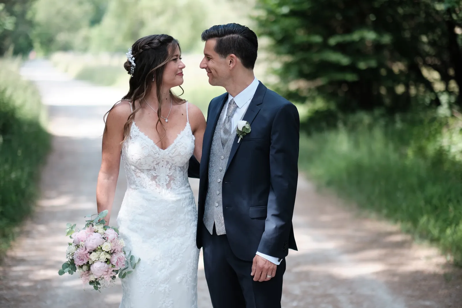 Brautpaar schaut sich lachend an auf dem Feldweg – Hochzeit Markus & Tanja, Königsbrunner Heide