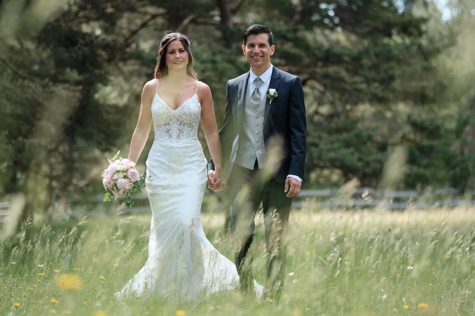 Brautpaar geht Hand in Hand durch die Wiese – Hochzeit Markus & Tanja, Königsbrunner Heide