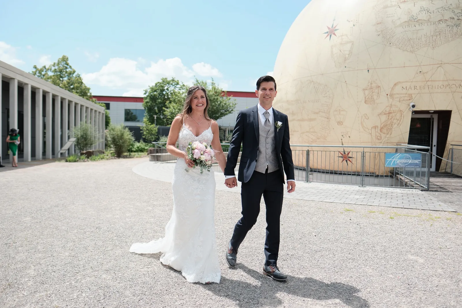 Brautpaar geht Hand in Hand durch die Kolonnade – Hochzeit Markus & Tanja, Eisstadion Königsbrunn
