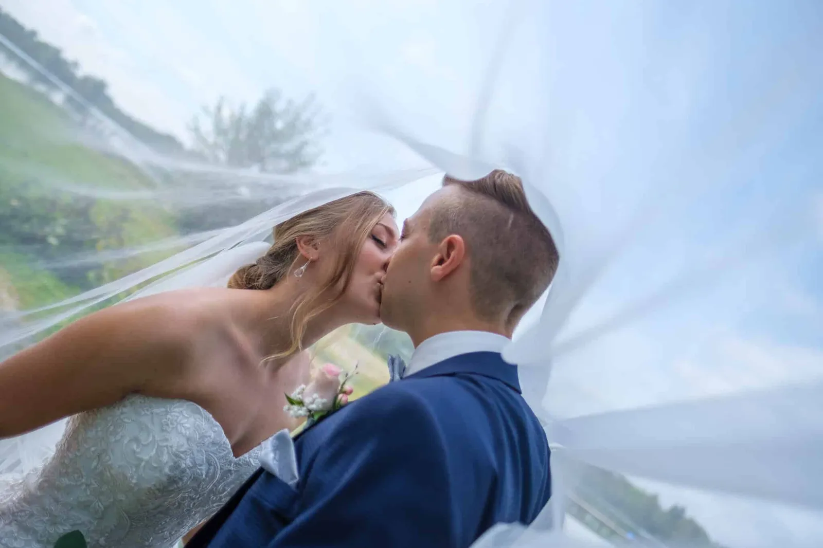 Brautpaar küsst sich unter dem Brautschleier – Hochzeit Alex & Dani