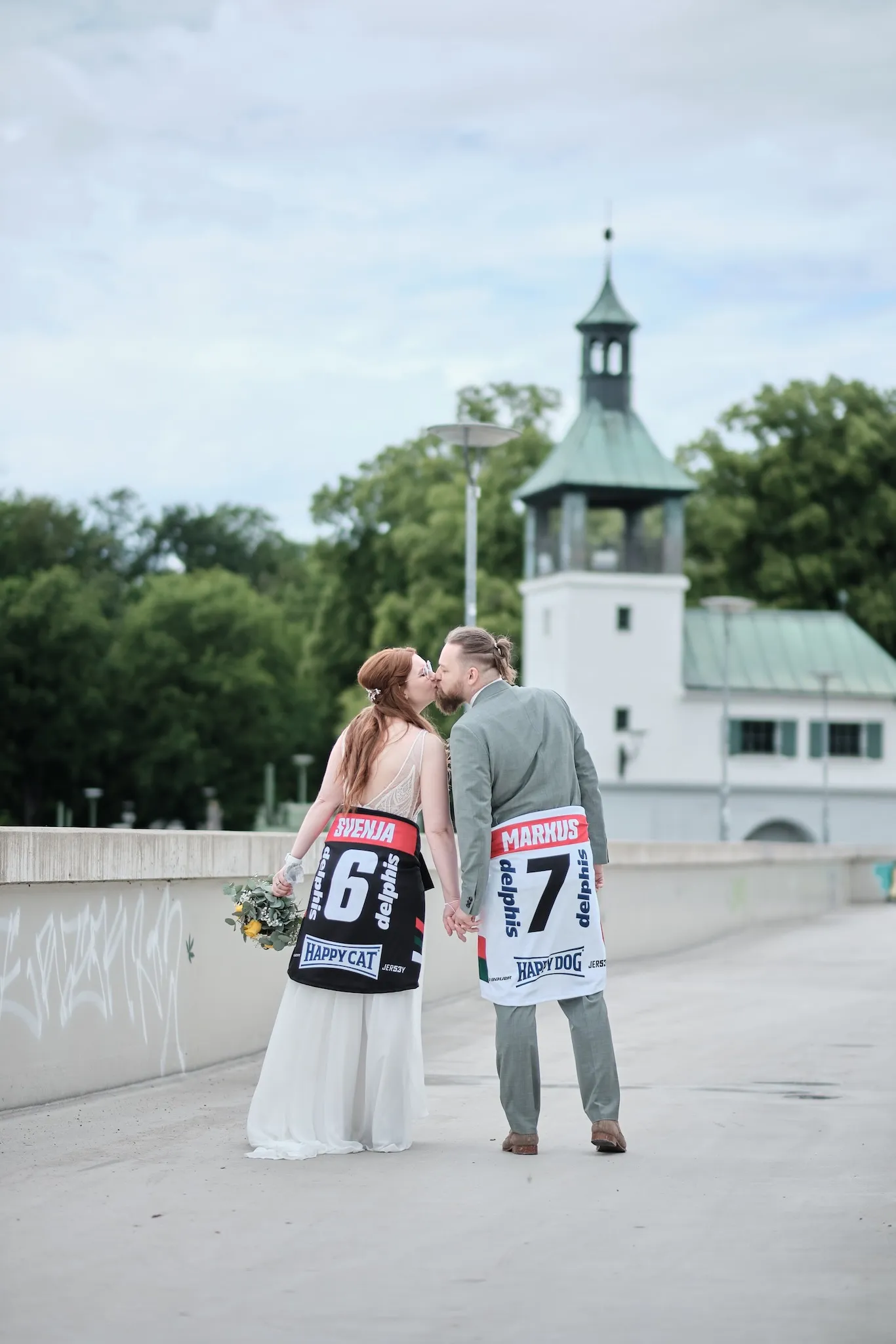 Brautpaar küsst sich in Trikots der Augsburger Panther mit den Nummern 6 und 7 – Hochzeit Svenja & Markus