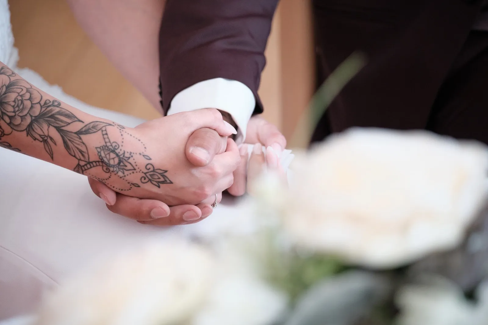 Tätowierte Hand von Denny hält Celinas Hand während der Trauung – Hochzeit Celina & Denny, Rathaus Diedorf