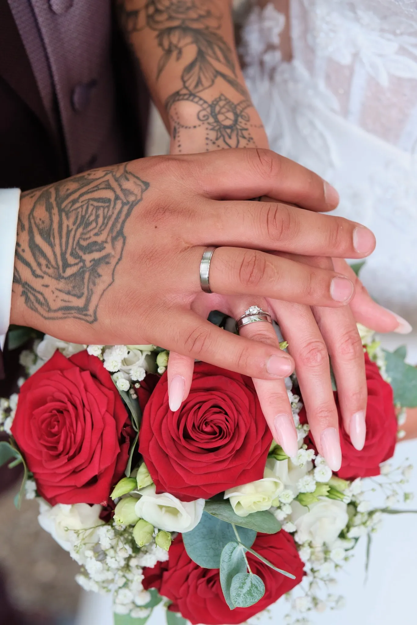 Hände mit Eheringen auf dem Brautstrauß aus roten Rosen – Hochzeit Celina & Denny