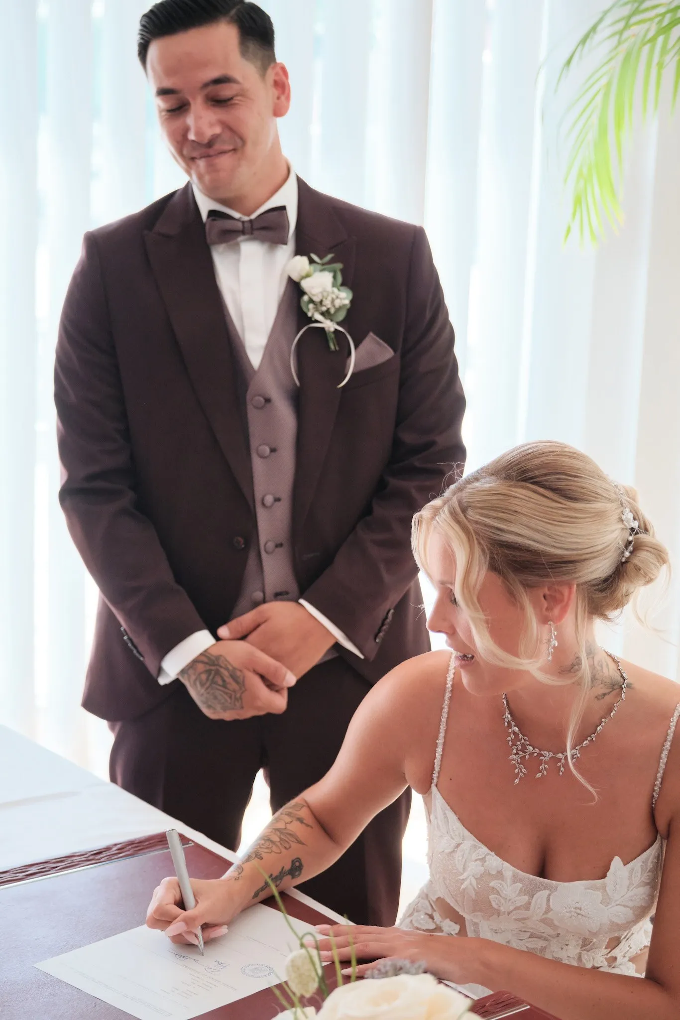 Celina unterschreibt die Heiratsurkunde, Denny steht lächelnd hinter ihr – Hochzeit Celina & Denny, Rathaus Diedorf