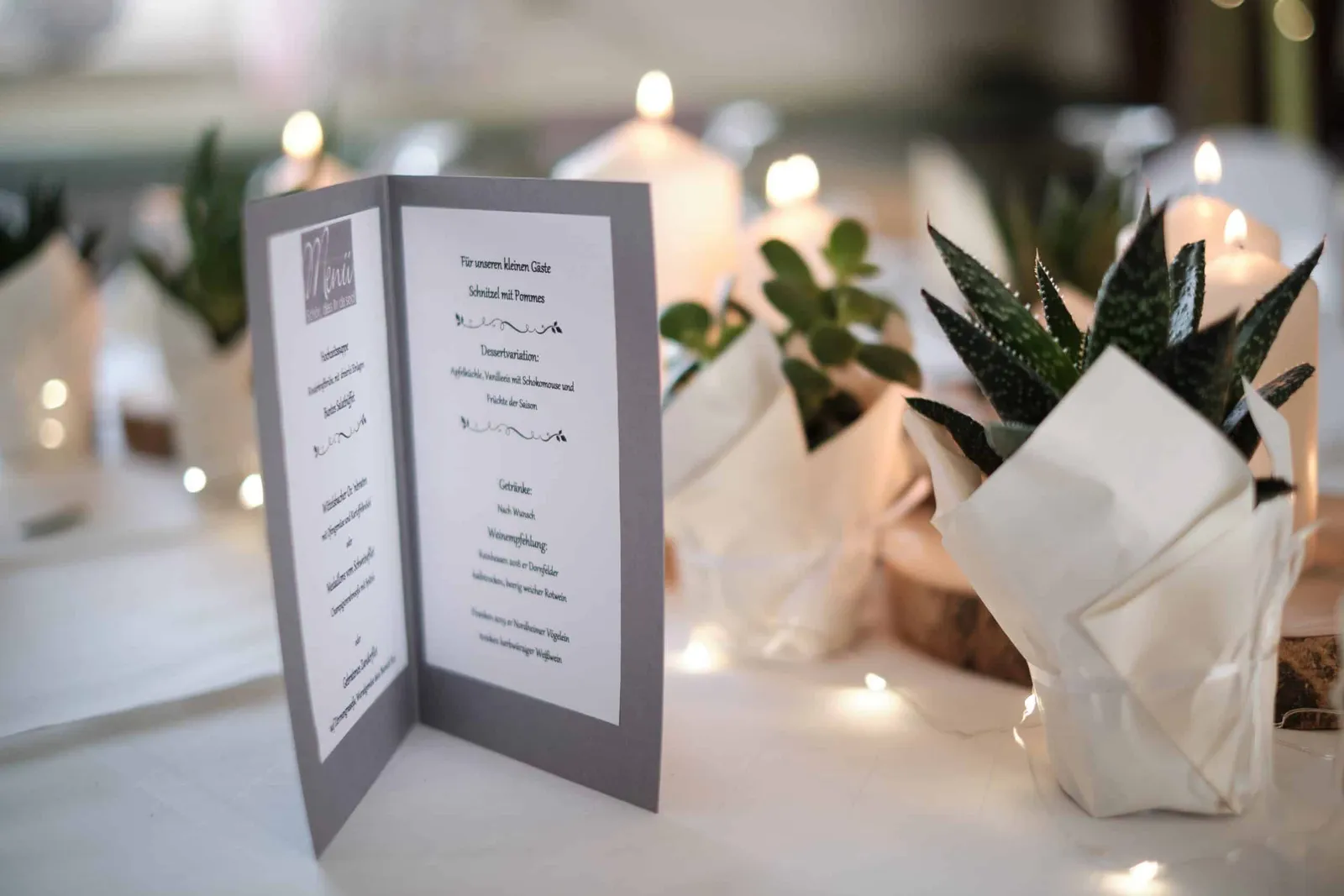 Aufgeklappte Menükarte zwischen Kerzen und Sukkulenten auf der Tafel – Hochzeit Andi & Betti, Schaezlerpalais