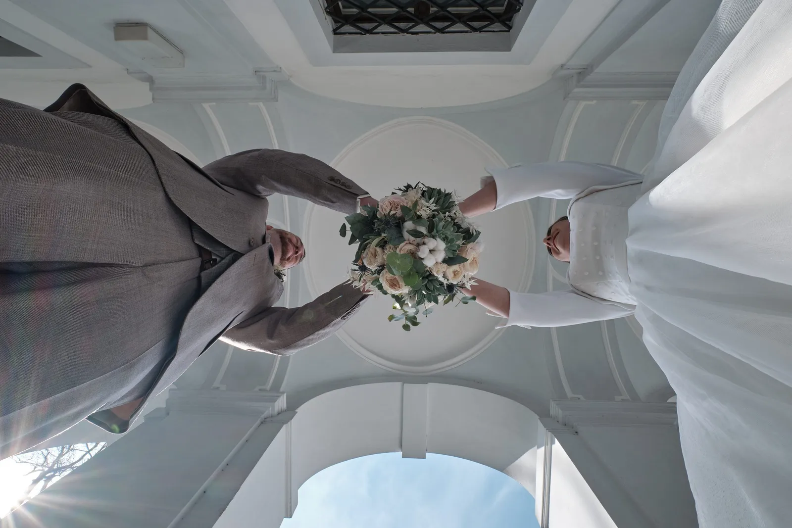 Brautpaar mit Brautstrauß von unten unter einer Kuppel fotografiert – Hochzeit Andi & Betti