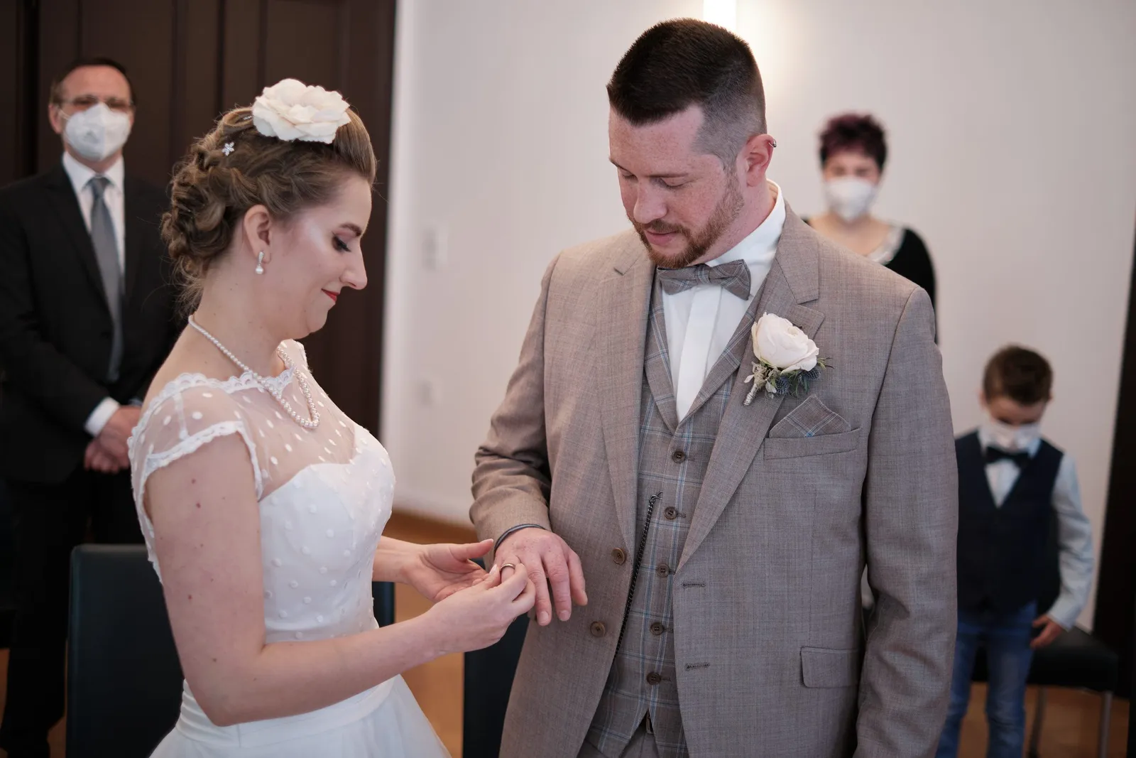 Braut steckt dem Bräutigam beim Ringtausch den Ehering an – Hochzeit Andi & Betti, Schaezlerpalais