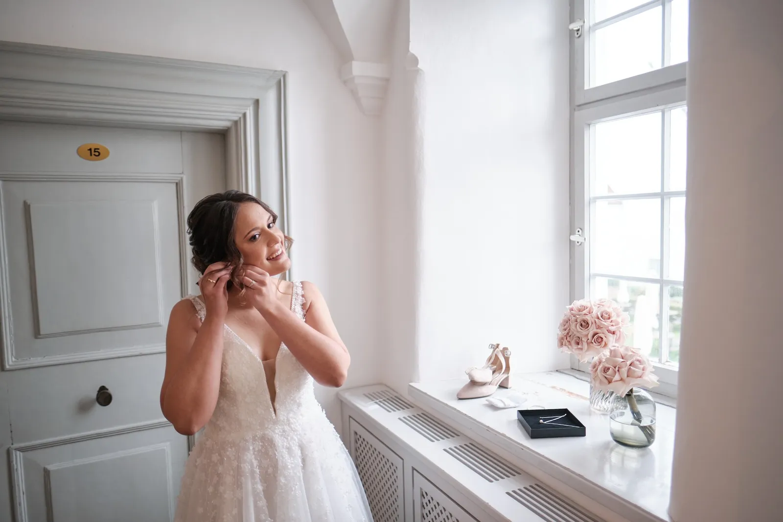 Braut beim Getting Ready, Helferin richtet die Frisur – Hochzeit Barbara & Christian, Schloss Neuburg a.d. Kammel