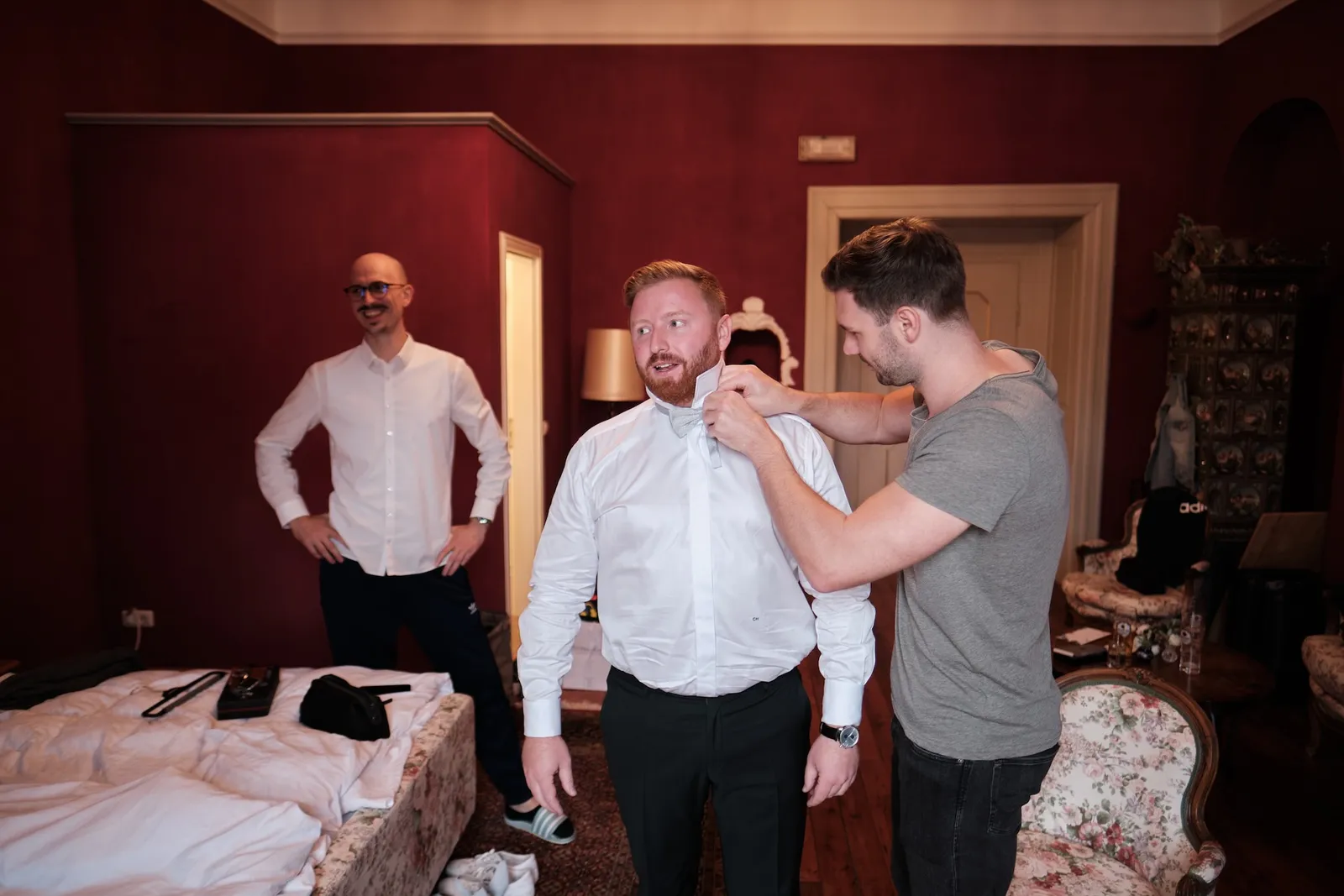 Trauzeuge hilft dem Bräutigam beim Hemd – Hochzeit Barbara & Christian, Schloss Neuburg a.d. Kammel