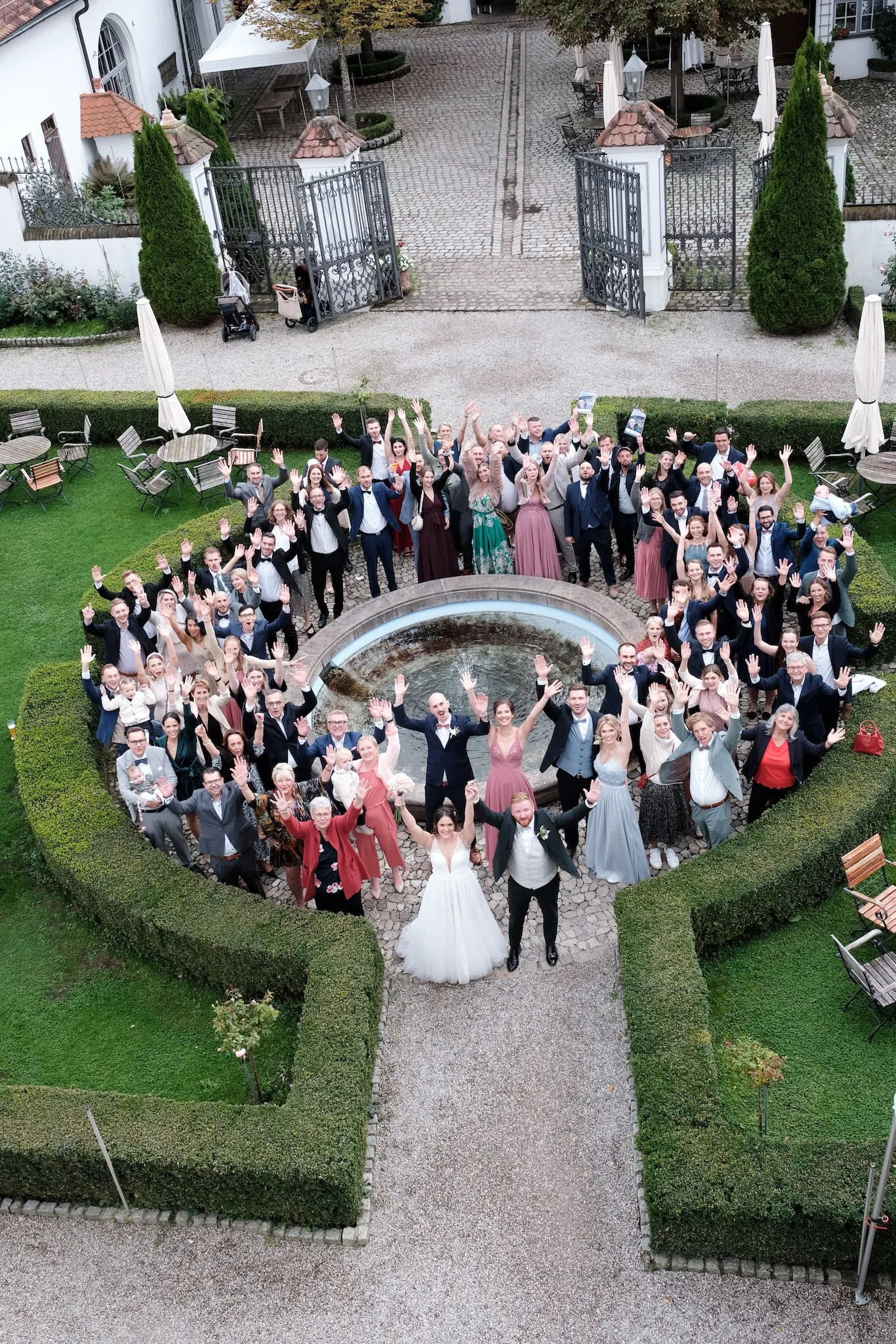 Luftaufnahme der ganzen Hochzeitsgesellschaft am Brunnen im Schlossgarten – Hochzeit Barbara & Christian, Schloss Neuburg a.d. Kammel