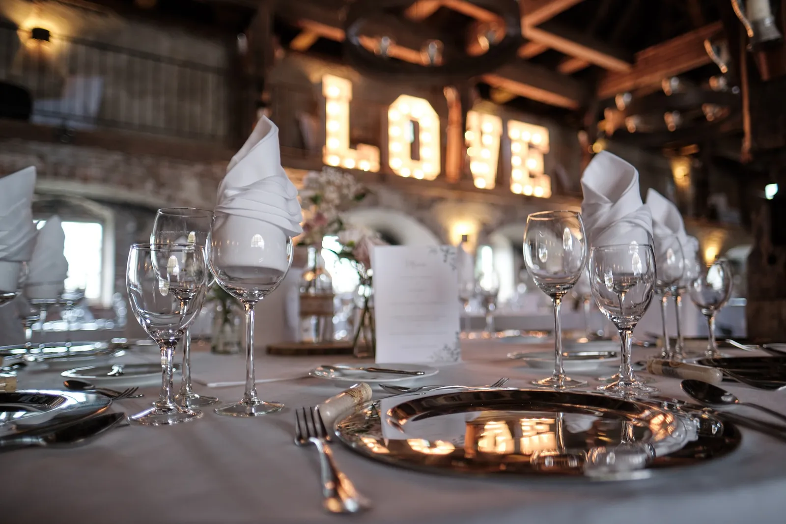Gedeckter Tisch mit Kerzen, LOVE-Schriftzug im Hintergrund – Hochzeit Barbara & Christian, Schloss Neuburg a.d. Kammel