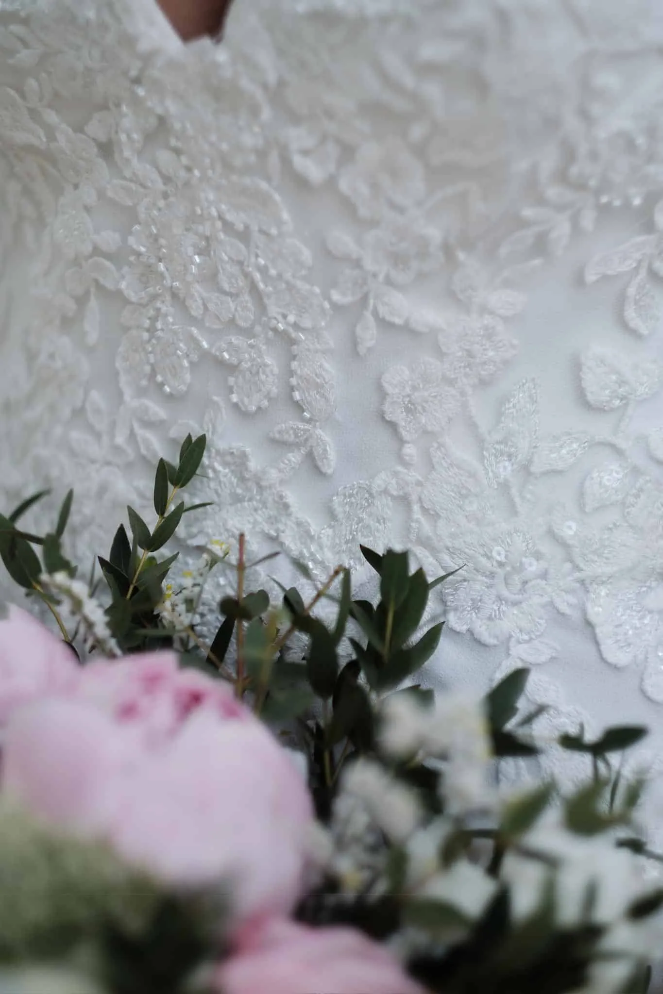 Spitze des Brautkleids mit rosa Pfingstrosen und Grün im Vordergrund – Hochzeit Jessie & Kosta, Wellenburger Allee