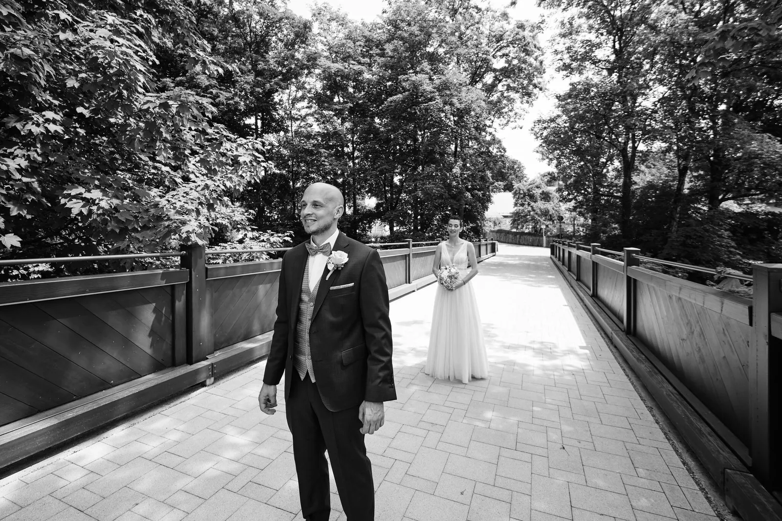 Martin wartet auf der Brücke zum Schloss, Nina kommt von hinten auf ihn zu – Hochzeit Martin & Nina, Wittelsbacher Schloss Friedberg