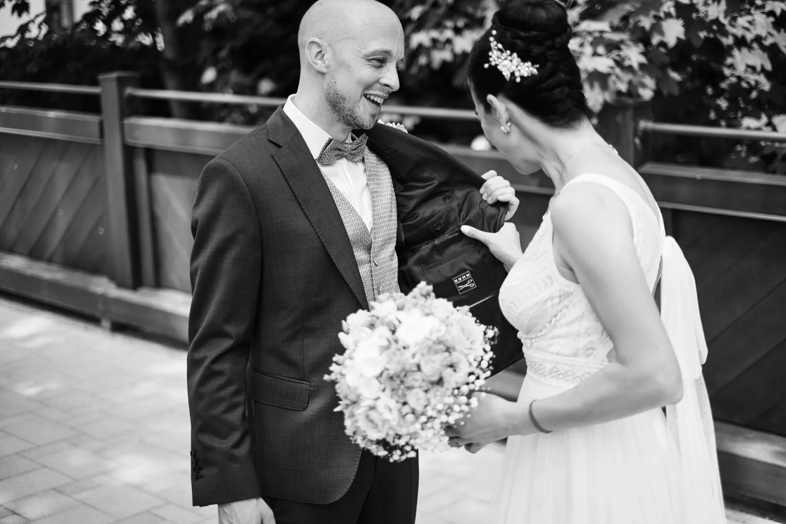 Martin öffnet lachend sein Sakko, Nina schaut hinein – Hochzeit Martin & Nina, Wittelsbacher Schloss Friedberg