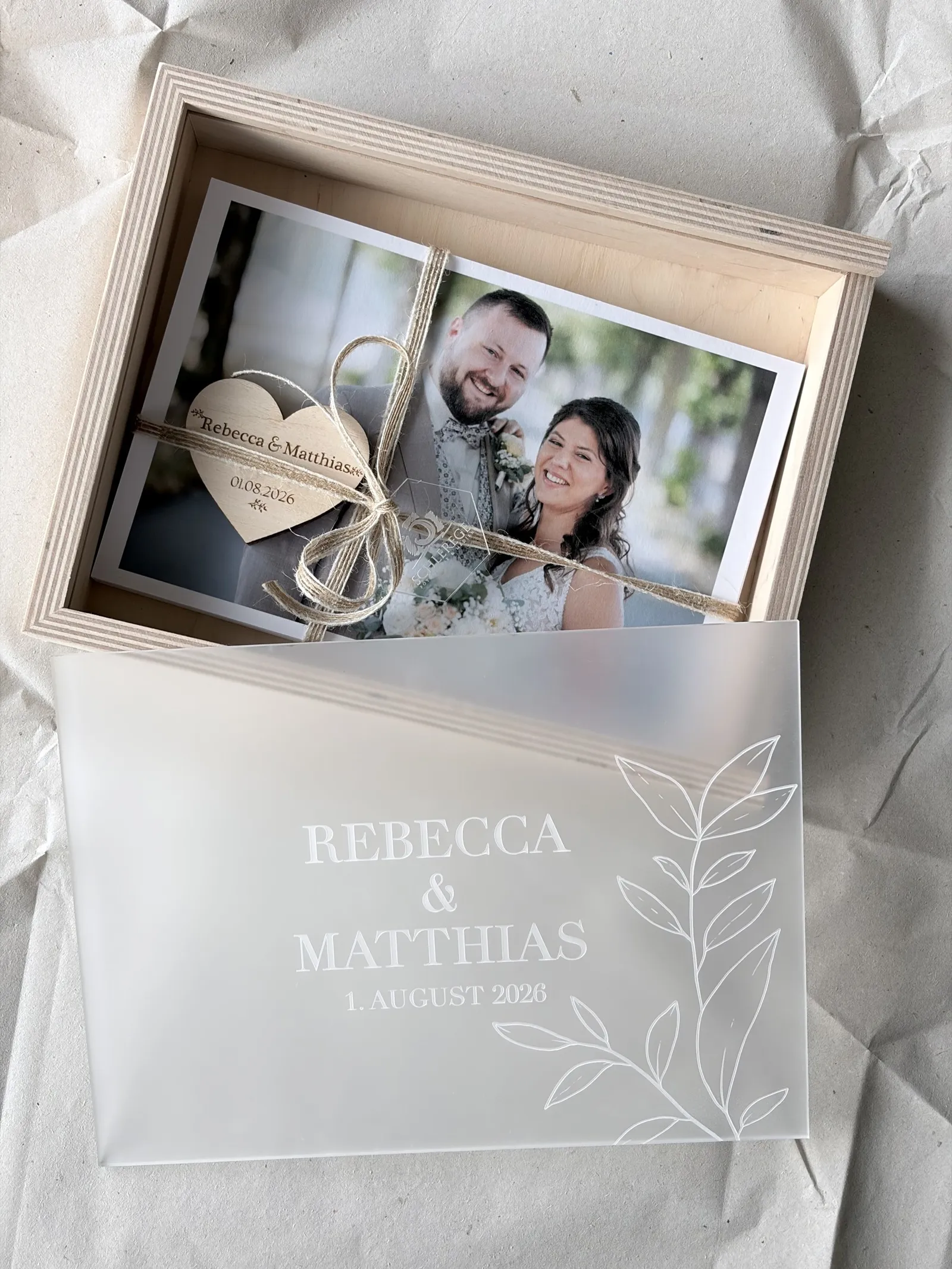 Hochzeitsbox aus Holz mit graviertem Acrylglas-Deckel, darin Fine-Art-Prints mit Jutekordel und Holzherz