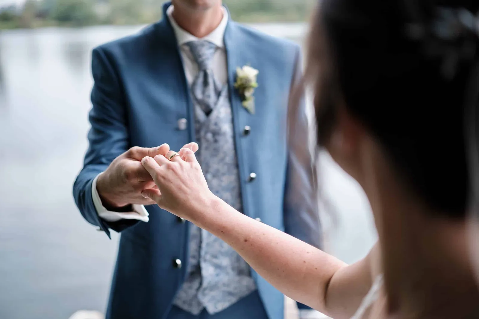 Braut hält die Hand des Bräutigams, über ihre Schulter fotografiert – Hochzeit Christina & Manuel